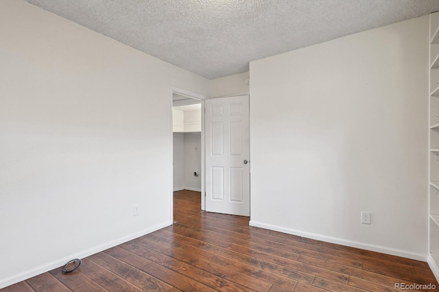 empty room featuring dark hardwood / wood-style floors and a textured ceiling