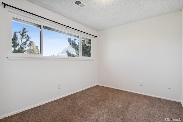 carpeted spare room with a textured ceiling