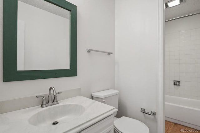 full bathroom with toilet, a textured ceiling, vanity, tiled shower / bath combo, and hardwood / wood-style floors