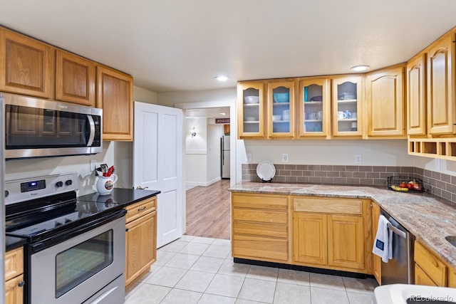 250 W Midway Blvd, Broomfield, CO 80020 - kitchen with stainless steel appliances, light tile patterned floors, glass insert cabinets, light stone counters, and recessed lighting