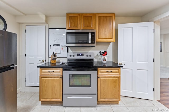 250 W Midway Blvd, Broomfield, CO 80020 - kitchen with appliances with stainless steel finishes, dark countertops, and light tile patterned floors