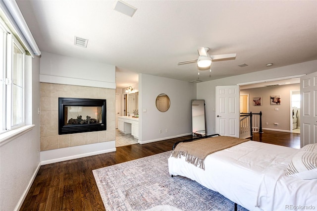 4970 Laurelglen Ln, Highlands Ranch, CO 80130 - bedroom featuring baseboards, dark wood-style flooring, a tile fireplace, and ceiling fan