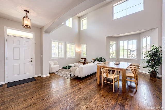 4970 Laurelglen Ln, Highlands Ranch, CO 80130 - dining room featuring dark wood-style floors, baseboards, and a towering ceiling