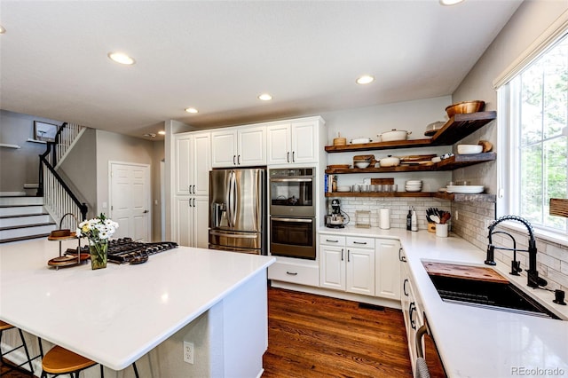 4970 Laurelglen Ln, Highlands Ranch, CO 80130 - kitchen featuring stainless steel appliances, a sink, open shelves, light countertops, and tasteful backsplash