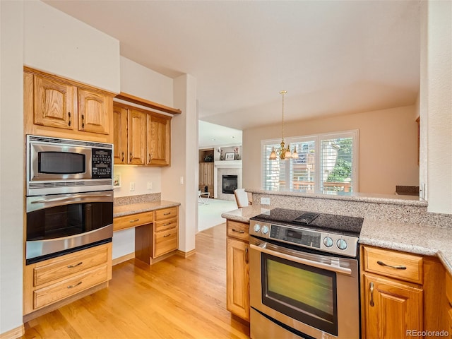 kitchen featuring pendant lighting, light hardwood / wood-style flooring, a notable chandelier, light stone counters, and stainless steel appliances