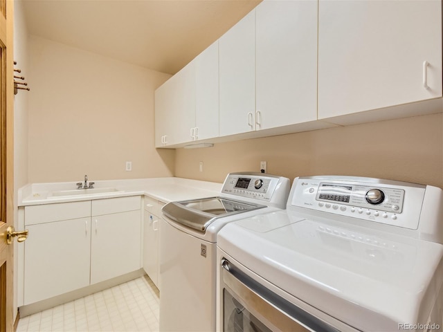 laundry room with washing machine and dryer, sink, and cabinets