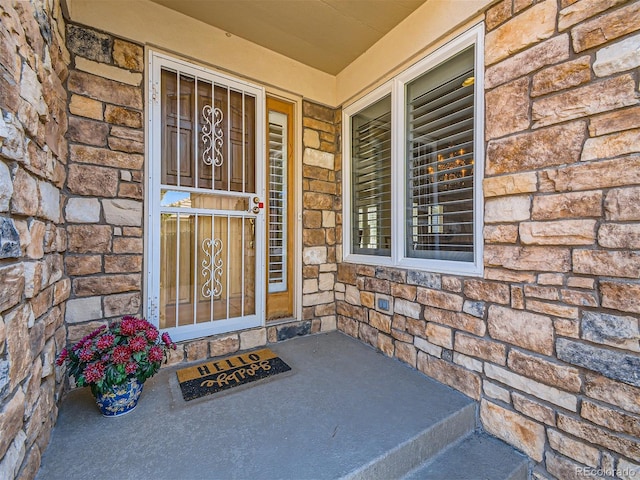 doorway to property with stone siding