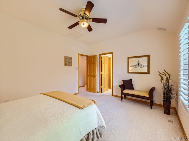 bedroom with visible vents, light carpet, attic access, and vaulted ceiling