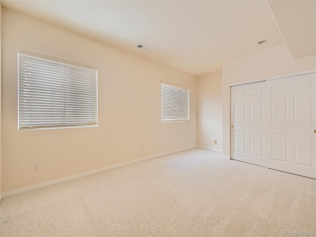 unfurnished bedroom featuring visible vents, carpet floors, baseboards, and a closet