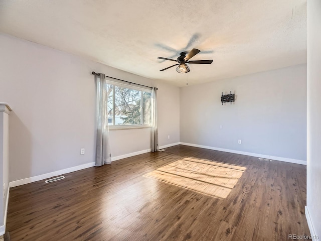 spare room featuring ceiling fan, dark hardwood / wood-style flooring, and a textured ceiling