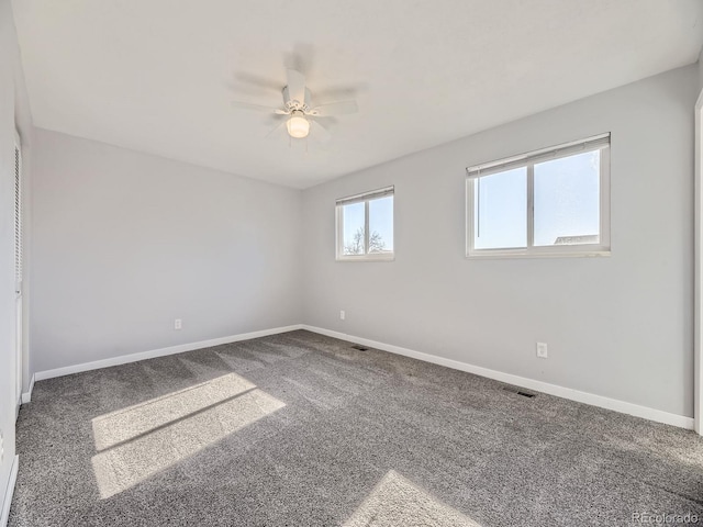 carpeted spare room featuring ceiling fan