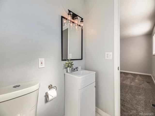 bathroom with vanity, toilet, and a textured ceiling