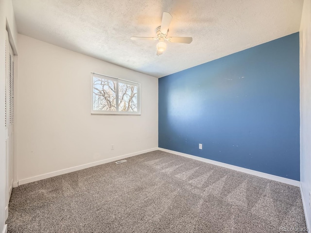 carpeted empty room featuring ceiling fan and a textured ceiling