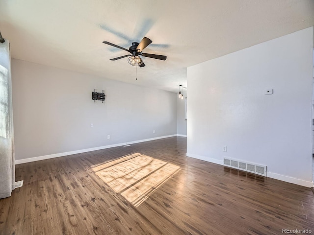 spare room featuring dark hardwood / wood-style flooring and ceiling fan