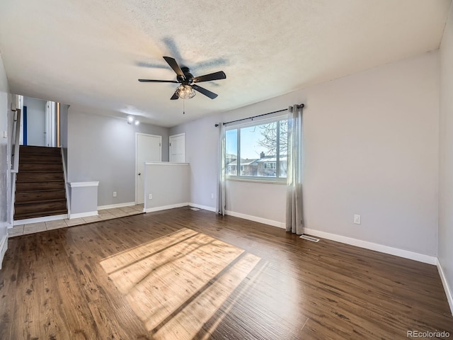 interior space with ceiling fan, dark wood-type flooring, and a textured ceiling