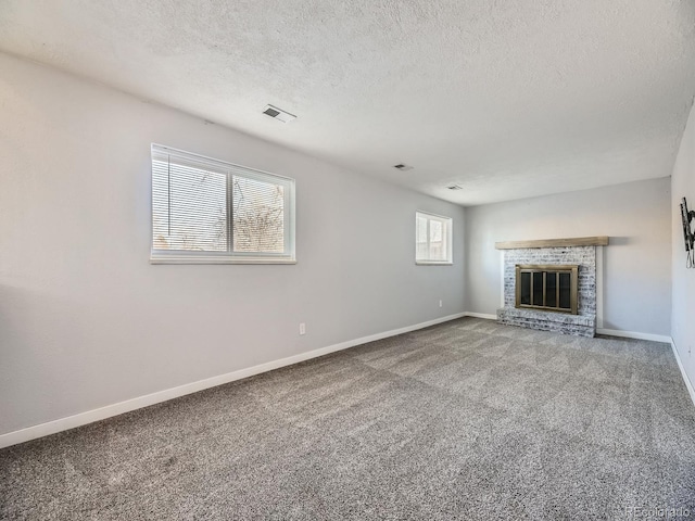 unfurnished living room featuring a fireplace, carpet floors, and a textured ceiling