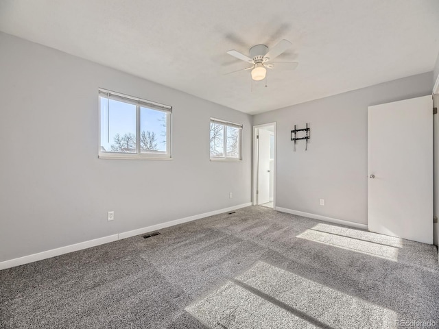 carpeted spare room featuring ceiling fan