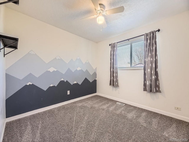 carpeted spare room with ceiling fan and a textured ceiling