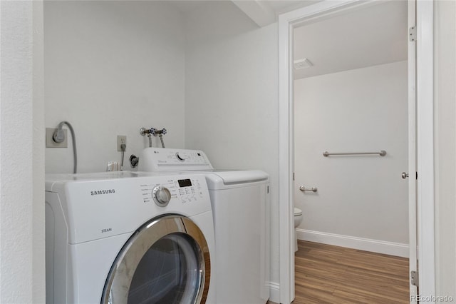 laundry room with separate washer and dryer, baseboards, laundry area, and wood finished floors