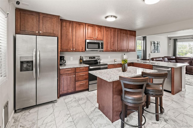 18672 E Chaffee Pl, Denver, CO 80249 - kitchen featuring stainless steel appliances, light marble finish flooring, a peninsula, and light stone countertops