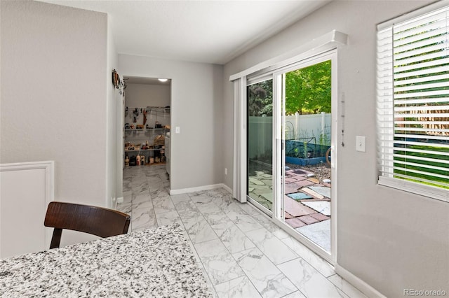 18672 E Chaffee Pl, Denver, CO 80249 - unfurnished dining area with light marble finish flooring and baseboards