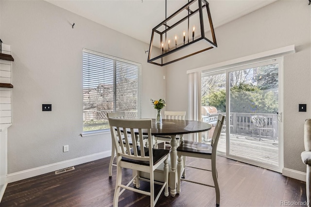 dining area featuring dark wood-type flooring and a chandelier