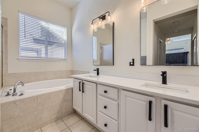 bathroom with vanity, tile patterned flooring, ceiling fan, and a relaxing tiled tub