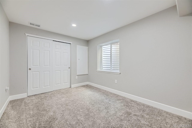 unfurnished bedroom featuring carpet flooring and a closet