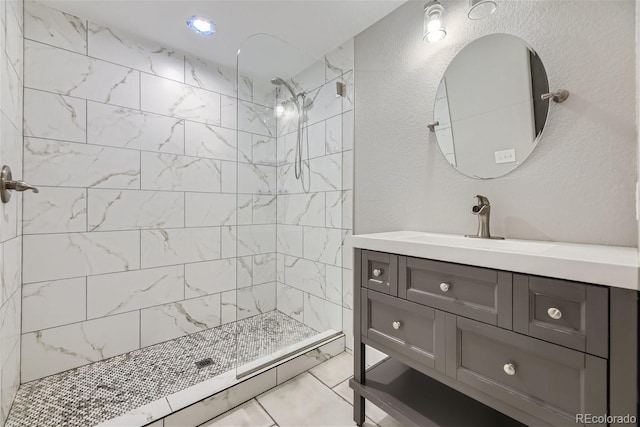 bathroom with vanity, tile patterned floors, and a tile shower