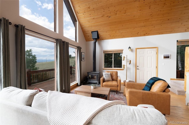 bedroom featuring a wood stove, high vaulted ceiling, access to exterior, wood finished floors, and wood ceiling