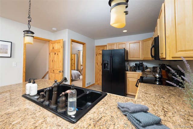 kitchen featuring visible vents, pendant lighting, a sink, black appliances, and light brown cabinets