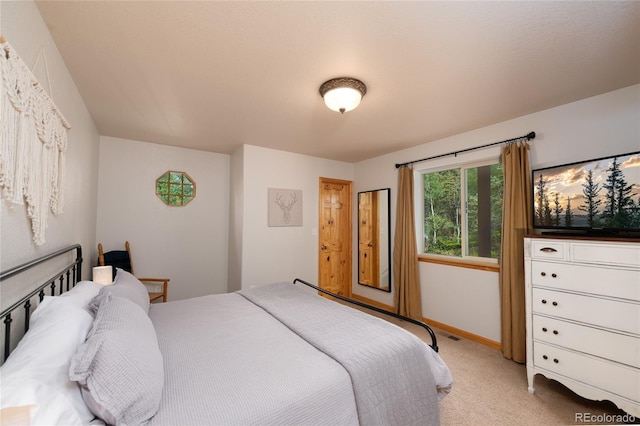 bedroom featuring baseboards and light carpet