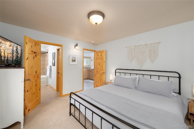 bedroom with light tile patterned floors, baseboards, ensuite bathroom, and light carpet