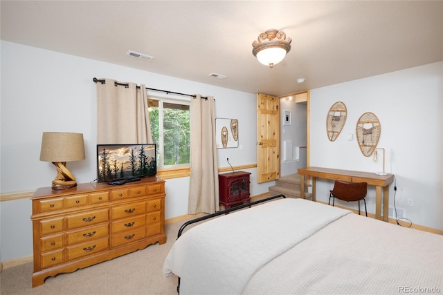 bedroom with visible vents, baseboards, and light carpet