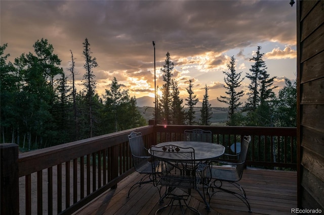 deck at dusk featuring outdoor dining area