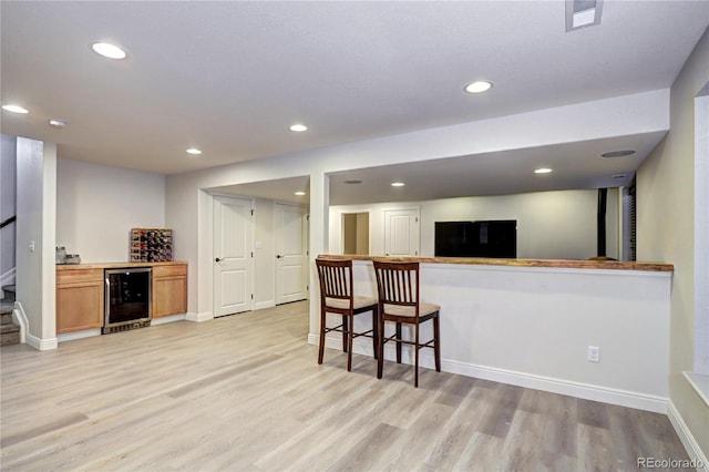 15160 W Iliff Pl, Lakewood, CO 80228 - kitchen with wine cooler, light wood-style floors, recessed lighting, and a kitchen bar