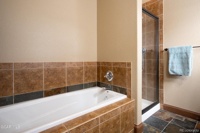 45 County Road 5223 Unit 25B, Tabernash, CO 80478 - bathroom with a bath, a textured wall, a stall shower, and stone finish floors