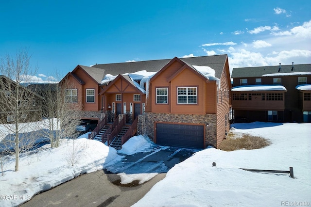 45 County Road 5223 Unit 25B, Tabernash, CO 80478 - view of front of home with stone siding, an attached garage, stairs, and driveway