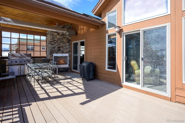45 County Road 5223 Unit 25B, Tabernash, CO 80478 - wooden deck with an outdoor stone fireplace, outdoor dining area, and grilling area