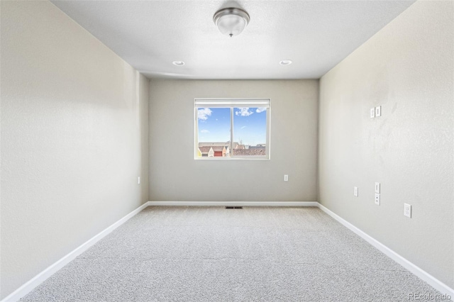 unfurnished room featuring visible vents, light colored carpet, and baseboards