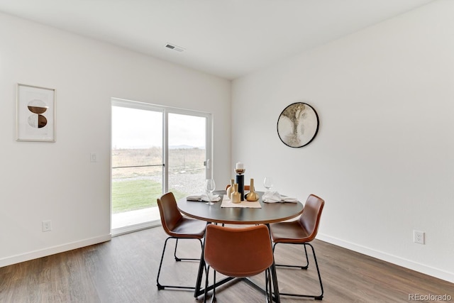 dining space with visible vents, wood finished floors, and baseboards