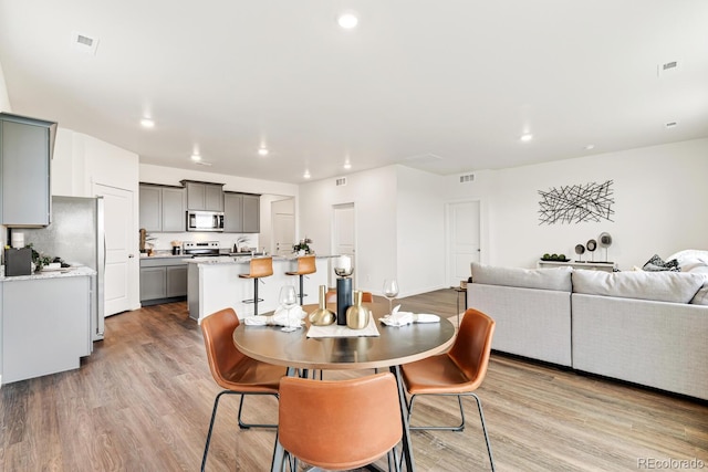 dining room featuring recessed lighting, light wood-style floors, and visible vents