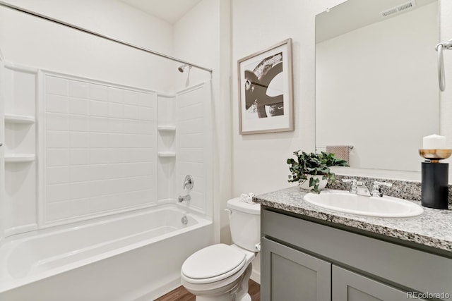 bathroom featuring visible vents, toilet, wood finished floors, shower / bath combination, and vanity