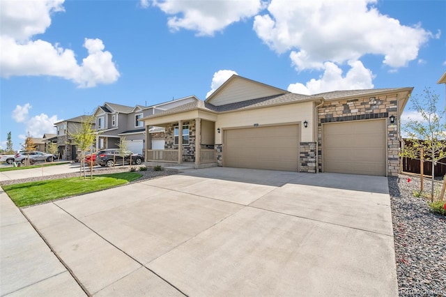 view of front facade with an attached garage, a residential view, stone siding, and driveway