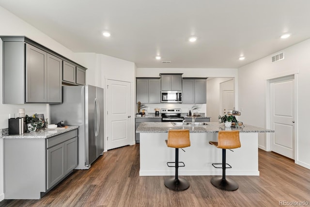 kitchen featuring dark wood-style flooring, visible vents, gray cabinets, and appliances with stainless steel finishes