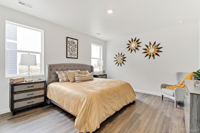 bedroom featuring visible vents, baseboards, and wood finished floors