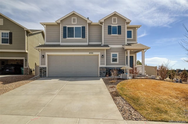 craftsman house featuring stone siding, a garage, and concrete driveway