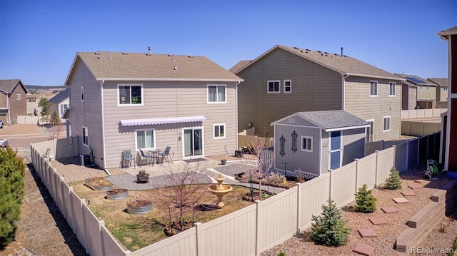 rear view of house featuring a patio area, a fenced backyard, a storage unit, central air condition unit, and an outbuilding