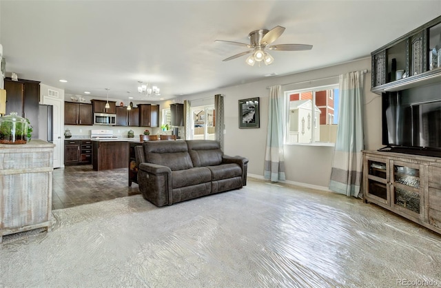living area with ceiling fan with notable chandelier, baseboards, and recessed lighting