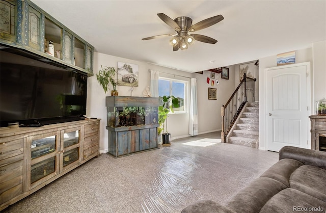 carpeted living area featuring ceiling fan, stairs, baseboards, and a fireplace